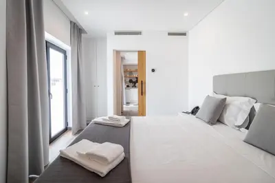 a bedroom with a large white bed with towels on it at Roots Hotel in Faro