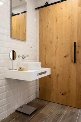 a bathroom with a sink and a wooden door at Roots Hotel in Faro
