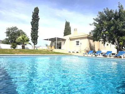 a swimming pool in front of a house at Villa Sunshine - Albufeira in Albufeira