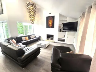 a living room with black leather furniture and a fireplace at Villa Sunshine - Albufeira in Albufeira