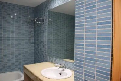 a blue tiled bathroom with a sink and a mirror at Charming 3-Bed Apartment in Albufeira in Albufeira