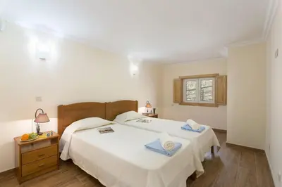 a bedroom with a large white bed and a window at Villa Falesia Mar by Villa Plus in Olhos de Água