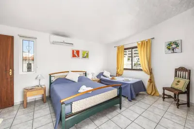 a bedroom with a bed and a table and window at Villa Lilly by Villa Plus in Albufeira