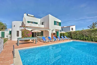 a villa with a swimming pool in front of a house at Villa Lilly by Villa Plus in Albufeira