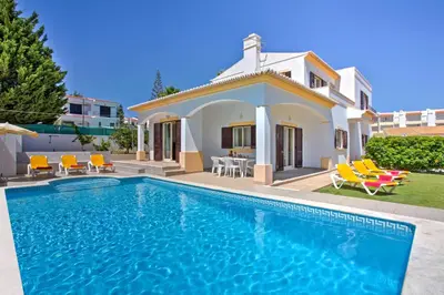 a villa with a swimming pool in front of a house at Villa Miraflores by Villa Plus in Albufeira