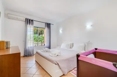 a bedroom with a bed with two towels on it at Villa Rafaela com piscina Albufeira in Albufeira