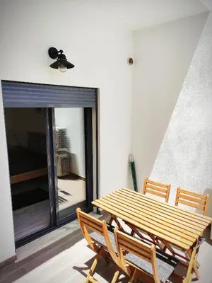 a wooden table and chairs in a room with a window at Apartamento Rooftop Montenegro in Faro