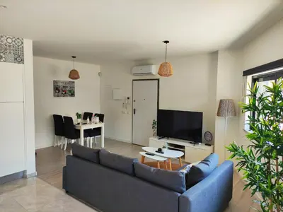 a living room with a blue couch and a tv at Apartamento Rooftop Montenegro in Faro