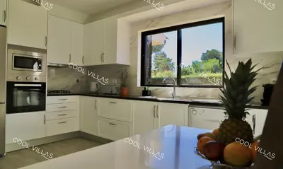 a kitchen with a window and a bowl of fruit on a table at Villa Lilac - walking distance to beach in Albufeira