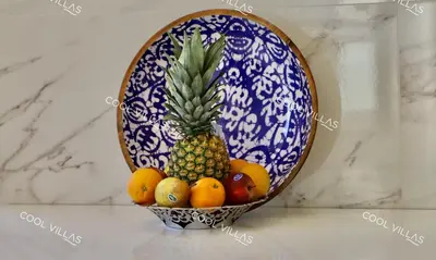 a bowl of fruit with a pineapple and oranges at Villa Lilac - walking distance to beach in Albufeira