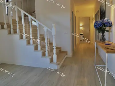 a staircase in a house with a vase of flowers at Villa Lilac - walking distance to beach in Albufeira