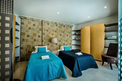 a room with two beds and a couch and a chair at Villa Laguna, Golf - Stunning house - Laguna Golf Course in Quarteira