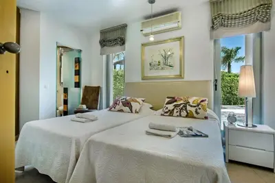 a bedroom with a large white bed with towels on it at Villa Laguna, Golf - Stunning house - Laguna Golf Course in Quarteira
