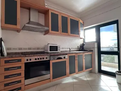a kitchen with a stove and a microwave at BayView Albufeira in Albufeira