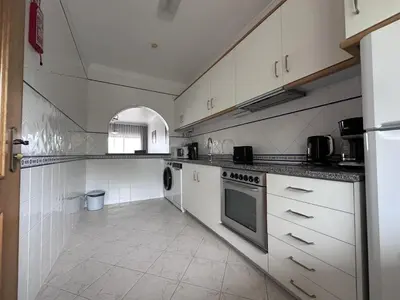 a large kitchen with white cabinets and a dishwasher at BayView Albufeira in Albufeira