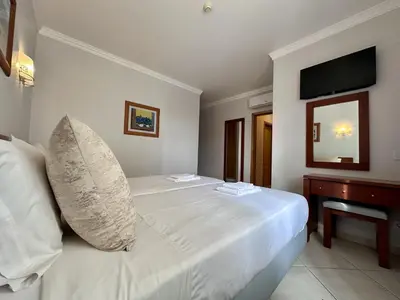 a white bed with a pillow on it in a room at BayView Albufeira in Albufeira