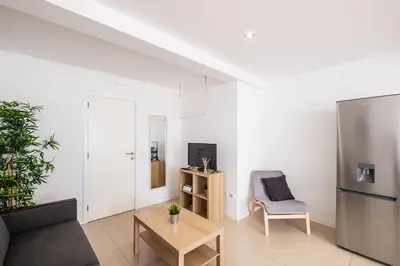 a living room with a refrigerator and a chair at Atlantic Breeze Apartments by Atlantic Places in Albufeira