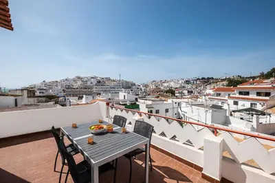 a table on a balcony with a view of a city at Atlantic Breeze Apartments by Atlantic Places in Albufeira