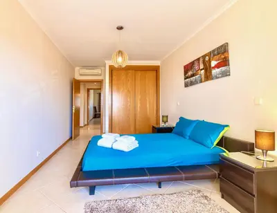 a bedroom with a blue bed with towels on it at Mar a Vista in Albufeira
