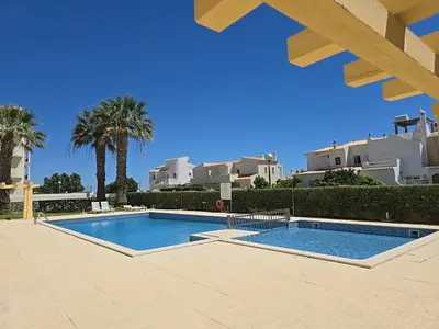 two white lounge chairs sitting next to a swimming pool at Mar a Vista in Albufeira