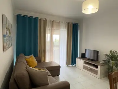 a living room with a couch and a tv at Apartamento Margarita in Quarteira
