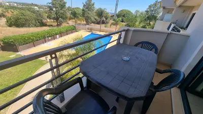 a table and chair on a balcony with a pool at Quinta do Pinheiro Premium by Sunny Deluxe in Olhos de Água