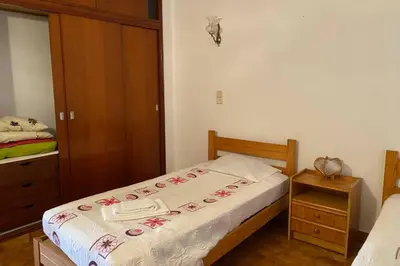 a small bedroom with a bed and a wooden cabinet at Casa d'Avó by RPG Properties in Albufeira