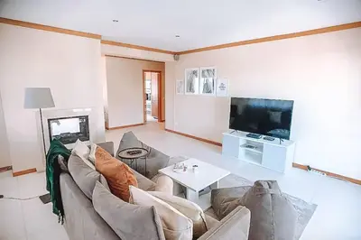 a living room with a couch and a table and a tv at Plant Paradise Apartment in Albufeira
