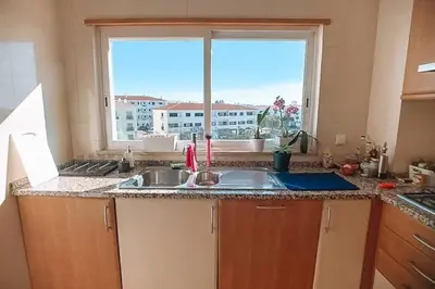 a kitchen with a sink and a large window at Plant Paradise Apartment in Albufeira