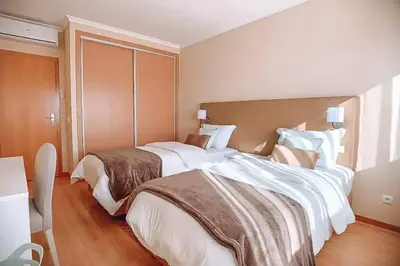 a hotel room with two beds with white sheets at Plant Paradise Apartment in Albufeira