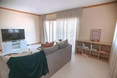 a living room with a couch and a flat screen tv at Plant Paradise Apartment in Albufeira