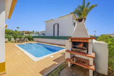 a backyard with a fireplace next to a swimming pool at Villa Anamar by Villa Plus in Albufeira