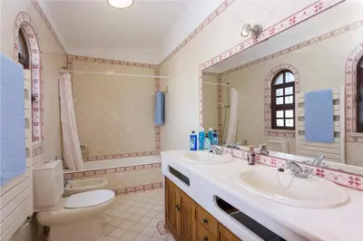 a bathroom with a sink and a toilet and a mirror at Villa Elanor by Villa Plus in Albufeira