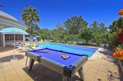 a pool table in front of a swimming pool at Villa Elanor by Villa Plus in Albufeira