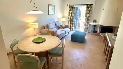 a living room with a table and a couch at Green and Blue View Apartment in Albufeira