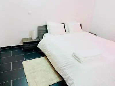 a white bed with white sheets and pillows in a room at Albufeira Beach side Apartment in Albufeira