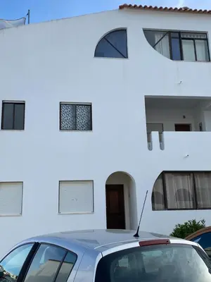 a car parked in front of a white house at Albufeira Beach side Apartment in Albufeira