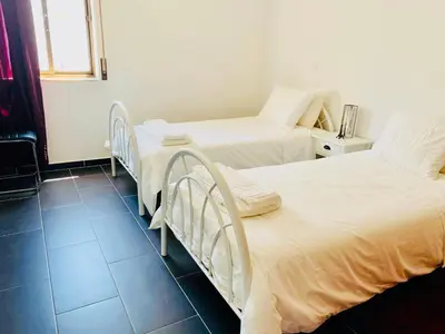two twin beds in a room with a window at Albufeira Beach side Apartment in Albufeira