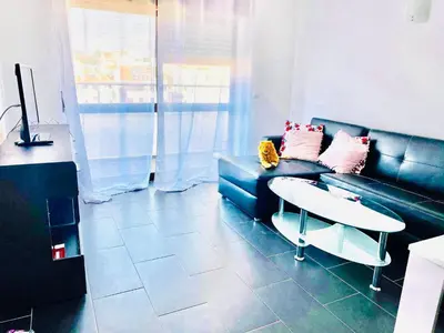 a living room with a blue couch and a table at Albufeira Beach side Apartment in Albufeira