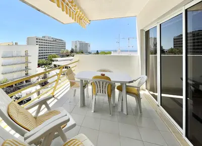 a balcony with a table and chairs on a building at Alcharb - Pool & City Center - Vilamoura in Quarteira