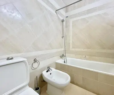 a white bathroom with a toilet and a bath tub at Alcharb - Pool & City Center - Vilamoura in Quarteira