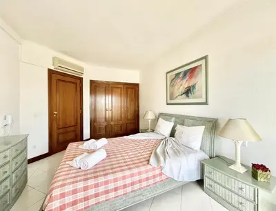 a bedroom with a bed with two towels on it at Alcharb - Pool & City Center - Vilamoura in Quarteira