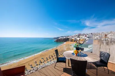 a white building on the side of a road next to the ocean at #041 Future House by Home Holidays in Albufeira