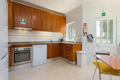a kitchen with wooden cabinets and a table and a table and chairs at Villa Nox in Brejos