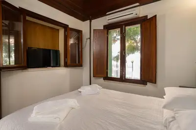 a bedroom with a bed with a tv and windows at Holiday villa in elite residential area of Faro in Faro
