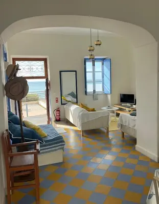 a living room with a yellow and blue tiled floor at Casa da Praia in Albufeira