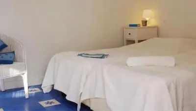 a bedroom with a white bed and a chair at Casa da Praia in Albufeira