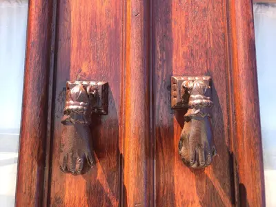 an old wooden door with bronze handles on it at Casa da Praia in Albufeira