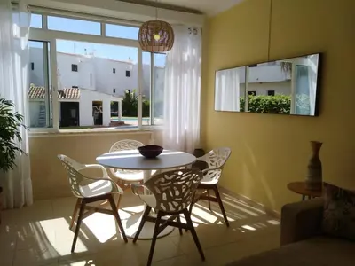 a dining room with a table and chairs and a window at Garden View Vilamoura Apartment in Vilamoura