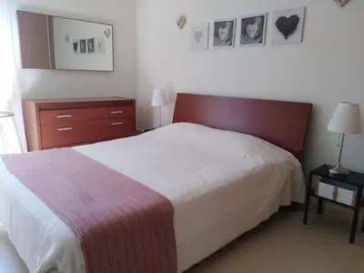 a bedroom with a large bed with a red headboard at Garden View Vilamoura Apartment in Vilamoura